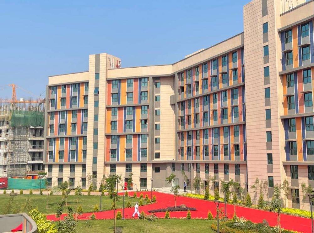 Colour-panelled facade of the BITSOM hostel block under a blue sky