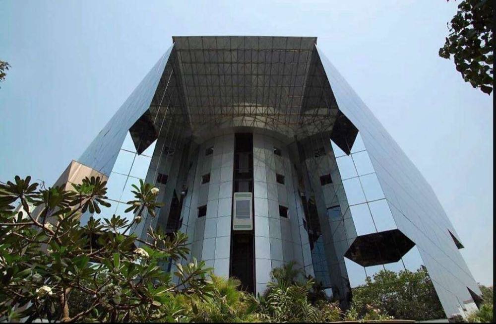 Faceted mirrored facade of the Vedanta Group corporate office viewed from below